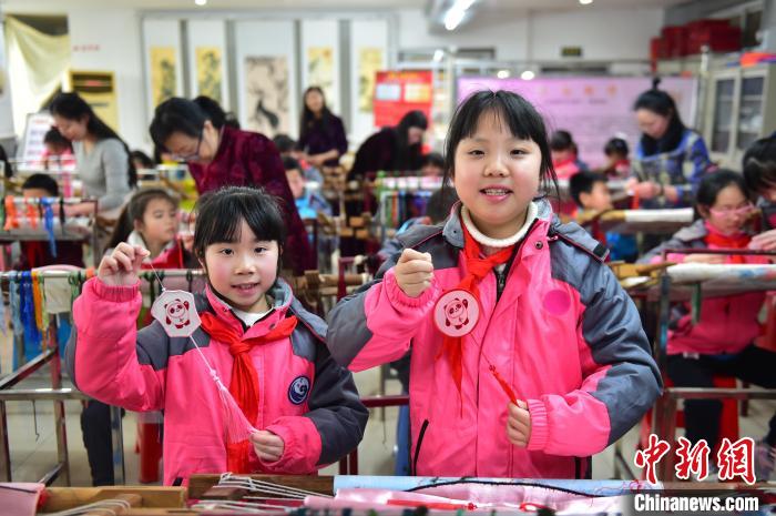 圖為小學(xué)生展示繡制好的2022年北京冬奧會(huì)吉祥物“冰墩墩”形象?！∮髟屏?攝