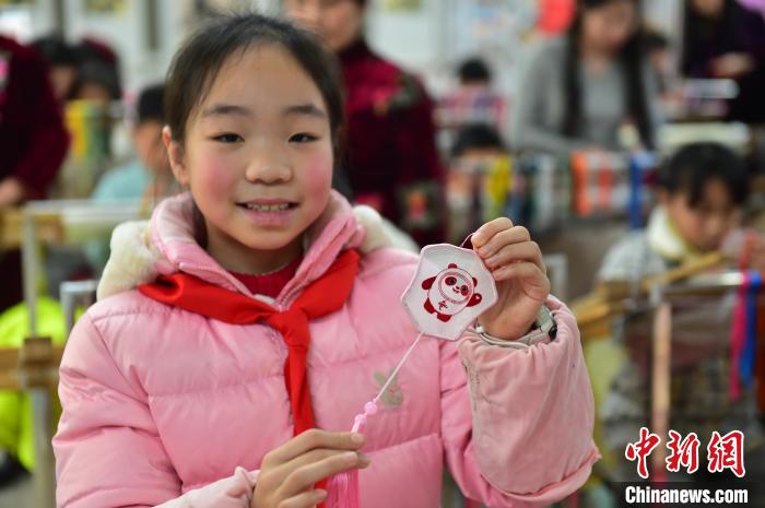 圖為一名小學(xué)生繡制的2022年北京冬奧會(huì)吉祥物“冰墩墩”形象。　喻云亮 攝