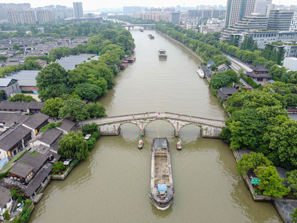 5月27日，一艘貨船駛過京杭大運(yùn)河南端標(biāo)志建筑杭州拱宸橋。(無人機(jī)照片)新華社記者江漢 攝