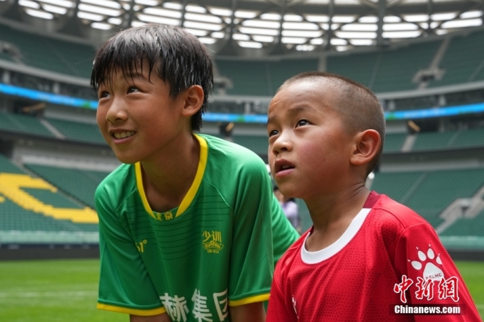 圖為北京國安小球員陳小北和7歲的俄金仁增在一起觀看場內(nèi)播放的紀錄片。<a target='_blank' href='/' _fcksavedurl='/'><p  align=