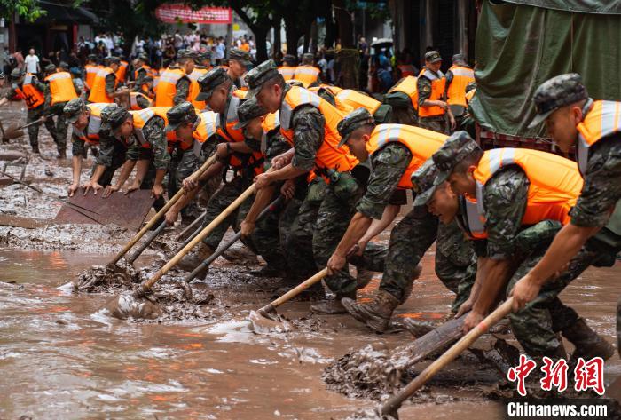 7月4日，萬(wàn)州區(qū)五橋街道，武警官兵清理街道上的淤泥?！∪矫宪?攝