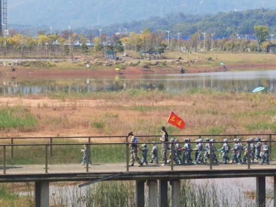 　　10月24日，秋游的幼兒園小朋友在老師帶領(lǐng)下走在清水塘公園里的木橋上。本報(bào)記者 常雯宜攝