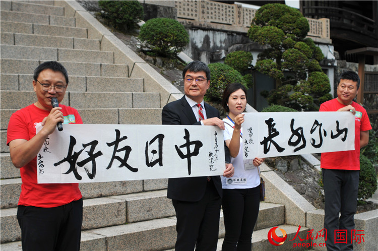 東京中國文化中心主任羅玉泉展示其為本次活動書寫的題詞“中日友好，山高水長”。人民網(wǎng) 蔣曉辰攝