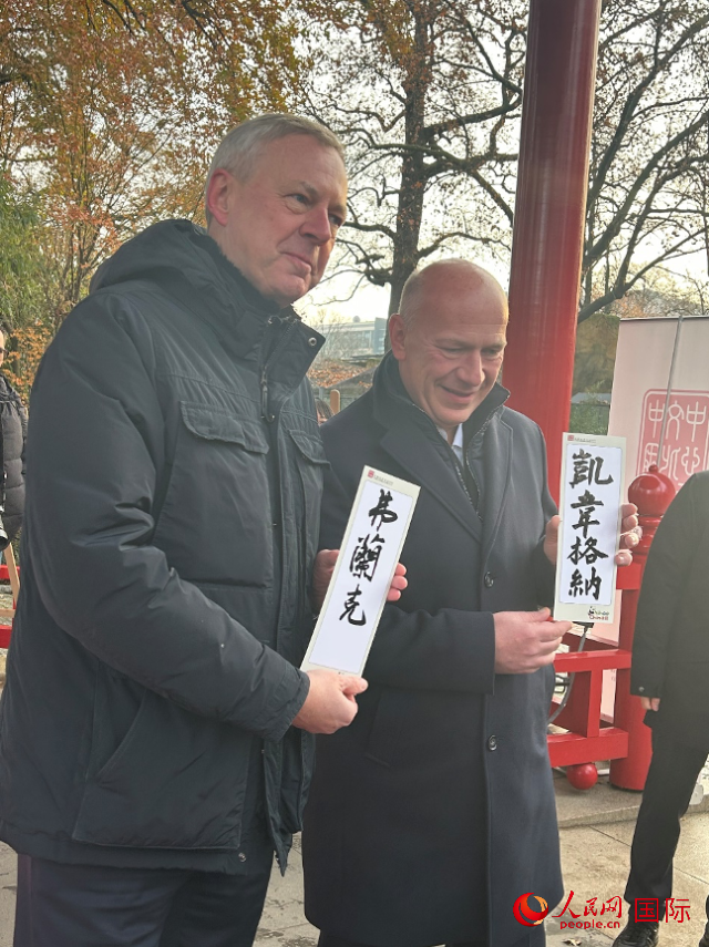 柏林市長韋格納（右）、動物園監(jiān)事會主席布魯克曼（左）手持中國文化中心工作人員現(xiàn)場手書的中文名字。人民網(wǎng)記者 徐馨攝