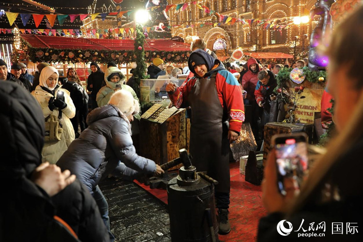 游客在新年集市上體驗(yàn)制作紀(jì)念幣。人民網(wǎng)記者 隋鑫攝