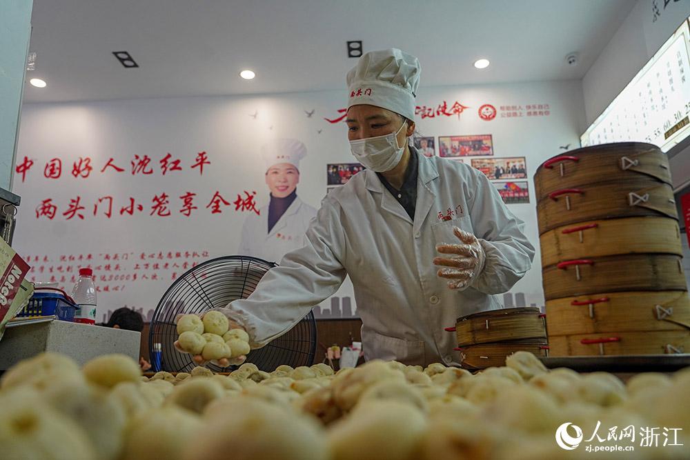 3月31日，在浙江省嵊州市甘霖鎮(zhèn)，嵊州小吃從業(yè)者沈紅平把蒸熟的小籠包晾涼，打包冷藏售賣。人民網(wǎng) 章勇濤攝