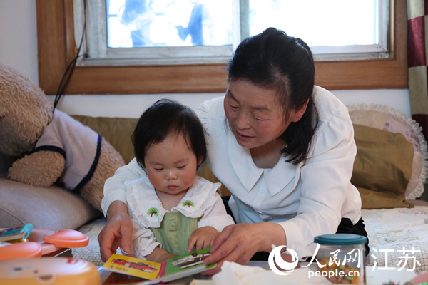 王繼蓮帶孫女看童書(shū)。人民網(wǎng) 冷金明攝