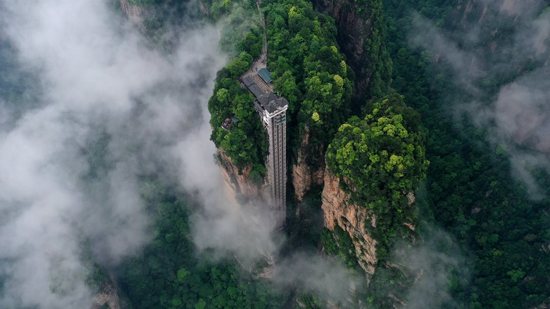 位于張家界武陵源景區(qū)的百龍?zhí)焯蓁偳对谠旗F繚繞的峰林間，雄偉壯觀。吳勇兵攝