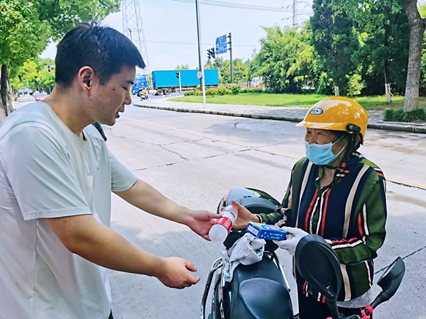 何超為過路的老人送上礦泉水和冷飲。人民網(wǎng)記者 王繼亮攝