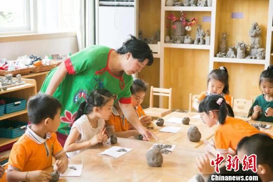 圖為劉雪玲正在給幼教中心的孩子上泥塑課。　鐘欣 攝