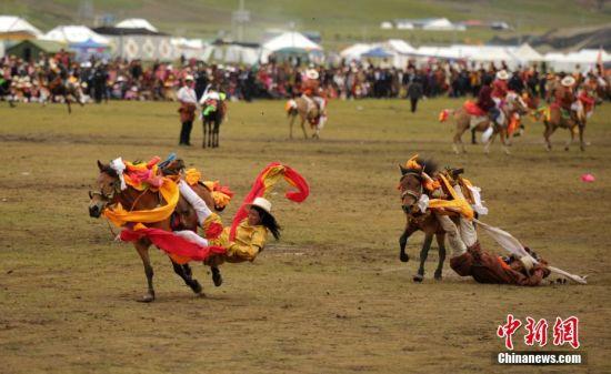 8月4日，四川理塘“八一”賽馬場上演一場精彩的馬術競技比賽，引來上萬民眾和游客觀賽。圖為牧民騎手進行五彩凌空競技。 中新社記者 劉忠俊 攝