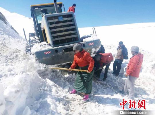 圖為普布卓瑪(左一)與養(yǎng)護(hù)工人一起抗擊雪災(zāi)，搶險(xiǎn)保通?！“⒗锏貐^(qū)公路養(yǎng)護(hù)段供圖 攝