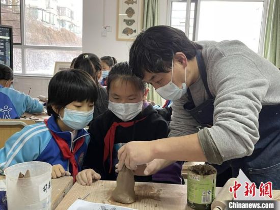 圖為西寧市勞動路小學(xué)教師賈煜與學(xué)生一起制作陶藝。　周瑞辰子 攝