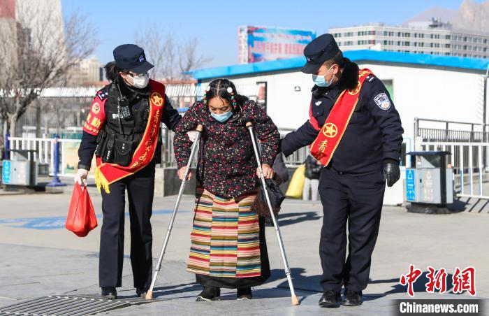 圖為拉薩鐵路公安民警幫助老人進站乘車?！『铲i 攝