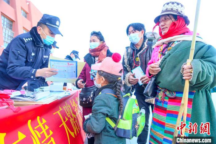 圖為拉薩鐵路公安民警向旅客發(fā)放乘車安全宣傳資料。　黃飛 攝