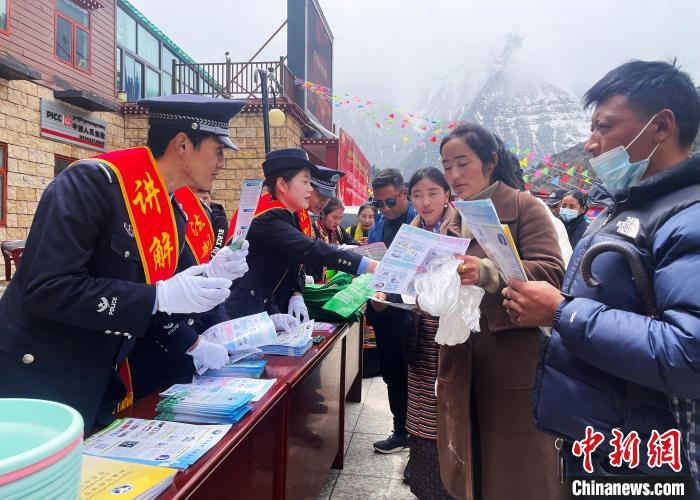 圖為山南玉麥邊境派出所民警為轄區(qū)群眾發(fā)放法律知識宣傳單?！＄婗?　攝