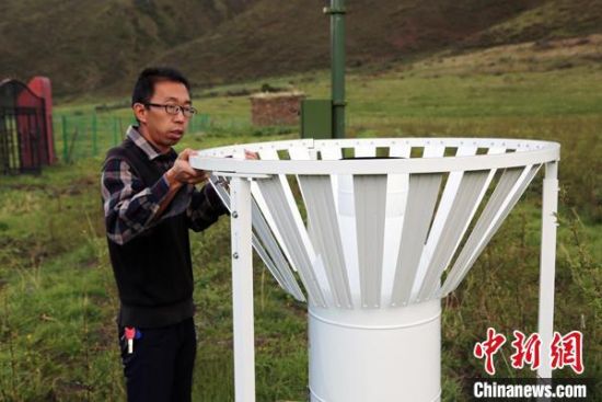 圖為班瑪縣氣象局工作人員在維護藏雪茶基地氣候站。青海省氣象局供圖