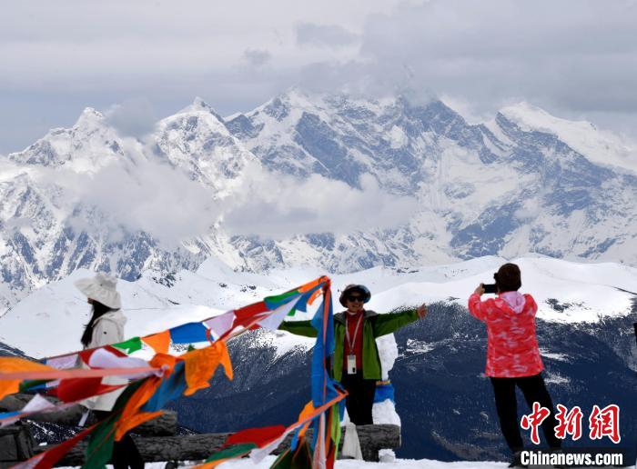 圖為5月14日，西藏林芝色季拉山觀景臺(tái)，游客與南迦巴瓦峰合影。　李林 攝