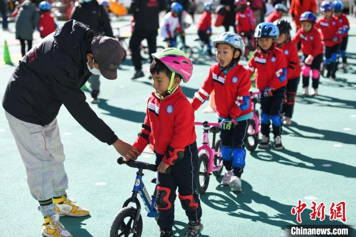 圖為拉薩市實(shí)驗(yàn)幼兒園孩子們在教練的指導(dǎo)下練習(xí)滑步車?！『闻罾?攝