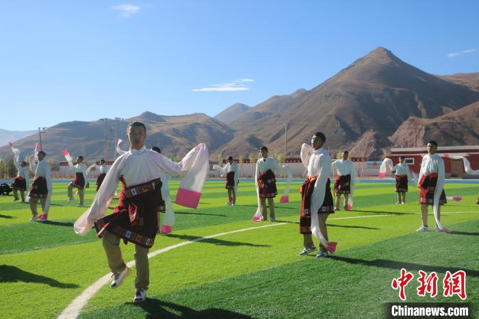 圖為青海師范大學(xué)附屬玉樹實驗學(xué)校學(xué)生在綠茵場跳起囊謙古舞—卓根瑪。　程雨 攝