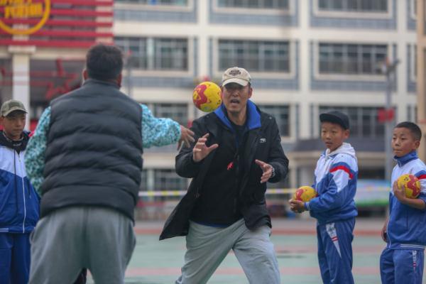 在高原上教孩子們打手球，“慢慢兒來，甭著急！”