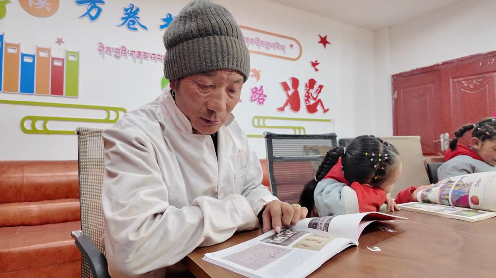 一位當(dāng)?shù)卮迕窈秃⒆觽冊谀良視堇锉M情享受閱讀時光。申扎縣融媒體中心供圖