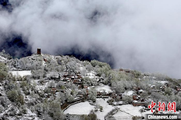 雪后的藏寨和碉樓構成美麗的雪景?！〗党鯘衫?攝