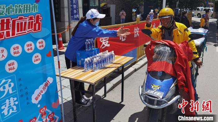 圖為近日，西藏自治區(qū)青年志愿者協(xié)會(huì)志愿者在拉薩街頭向快遞員送水。西藏自治區(qū)青年志愿者協(xié)會(huì) 供圖