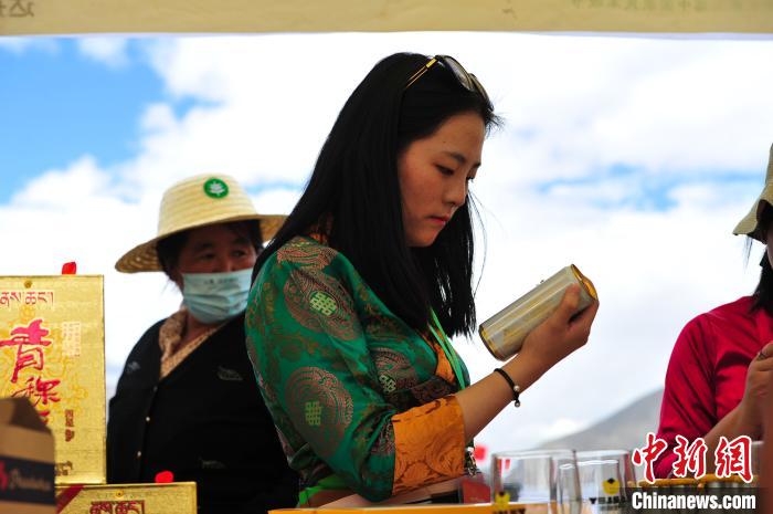 圖為拉薩市民在特色農(nóng)畜產(chǎn)品展示展銷會上選購商品?！垈?攝