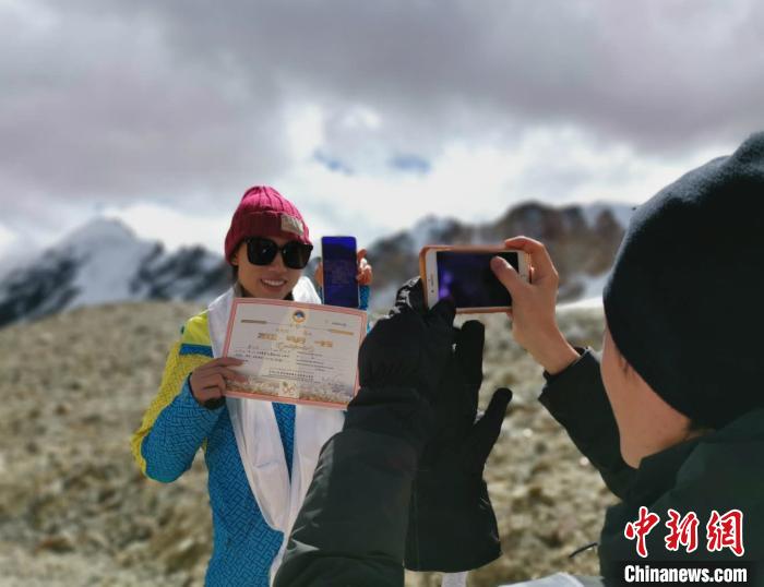 圖為5日，登頂洛堆峰的登山者獲得西藏自治區(qū)登山協(xié)會頒發(fā)的登頂證明?！垈?攝