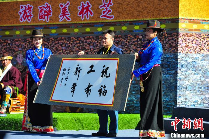 圖為14日，當(dāng)?shù)孛癖娛謱?xiě)工布新年賀詞?！垈?攝