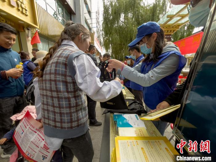 圖為志愿者為市民發(fā)放網(wǎng)絡(luò)安全宣傳手冊(cè)?！≈x牧 攝