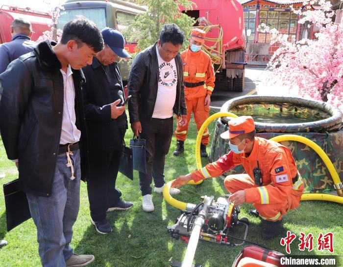 圖為森林消防員為護林員講解滅火裝備的使用方法?！〔际猩窒乐ш?供圖