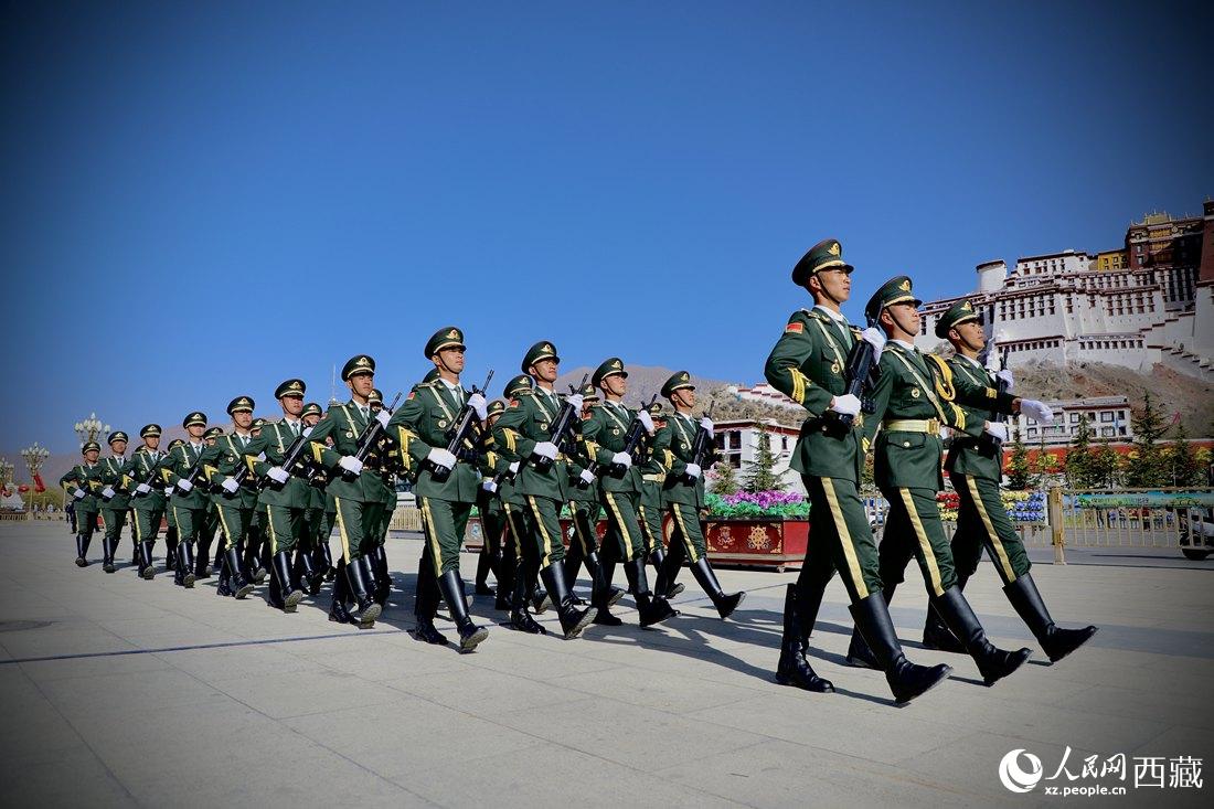 國旗護衛(wèi)隊隊員緊握鋼槍，踏著威武雄壯的步伐，走向國旗臺。人民網(wǎng) 次仁羅布攝