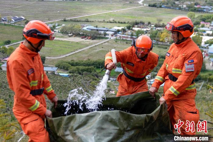 技能大練兵過程中，消防員在陡坡上向蓄水池注水。　李國(guó)燾 攝