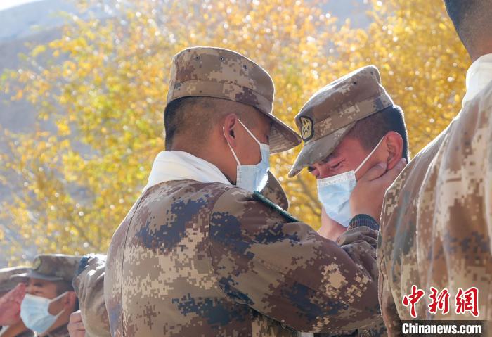 圖為什布奇邊防連退伍老兵與戰(zhàn)友相擁而泣，依依惜別。　徐昌成 攝