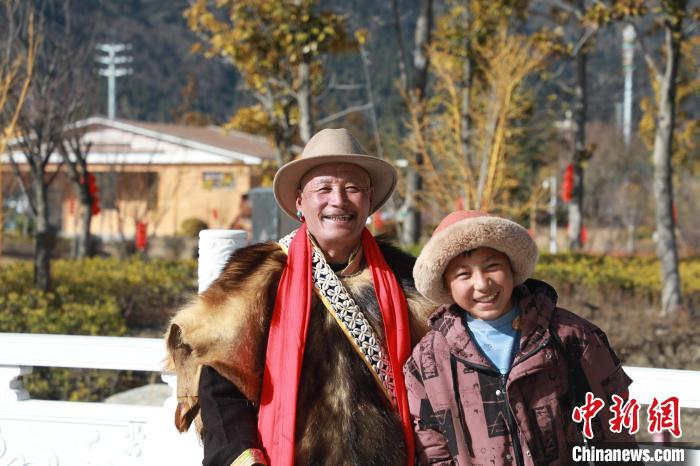 圖為林芝市巴宜區(qū)布久鄉(xiāng)仲果村村民桑杰與孫子一起參加藏歷新年活動?！埩?攝