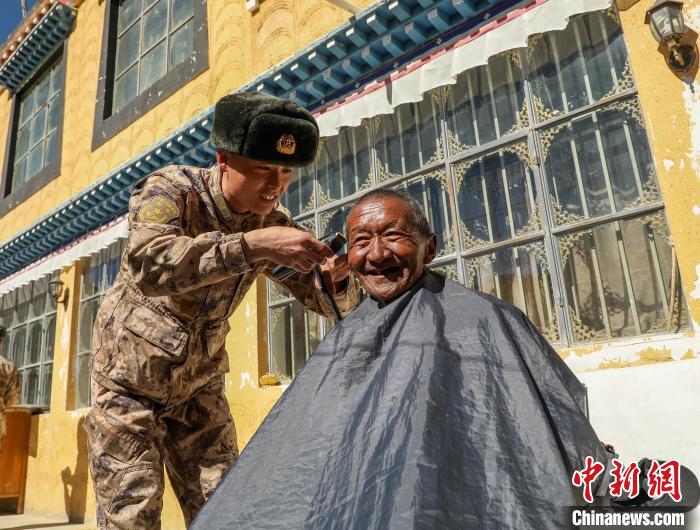 圖為阿里軍分區(qū)某邊防團(tuán)官兵為駐地群眾理發(fā)迎藏歷新年?！〉┰鰝愔?攝