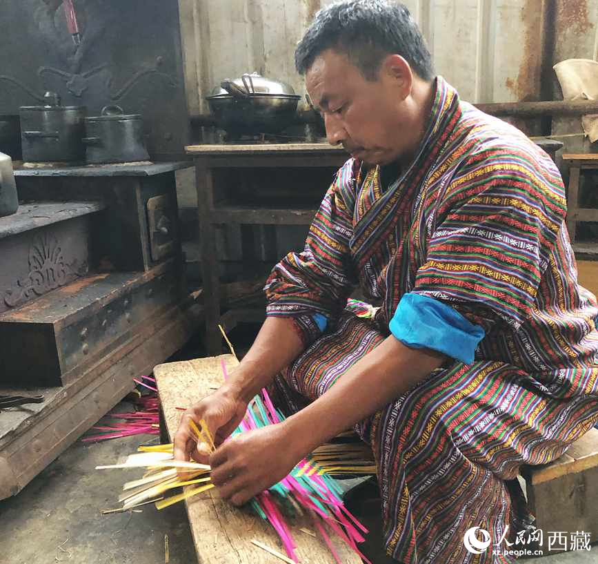 門巴族漢子愛明正在編織藤竹品。